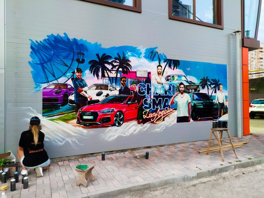Showcases an artist embellishing a Wall Printing Mural with spray paint grafitti