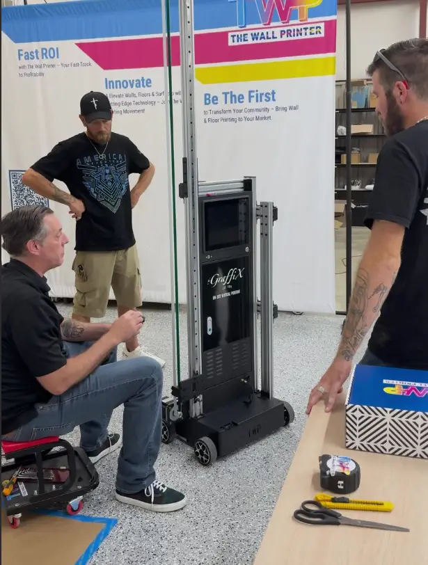 The Wall Printer team demonstrating a commercial wall printer during owner training