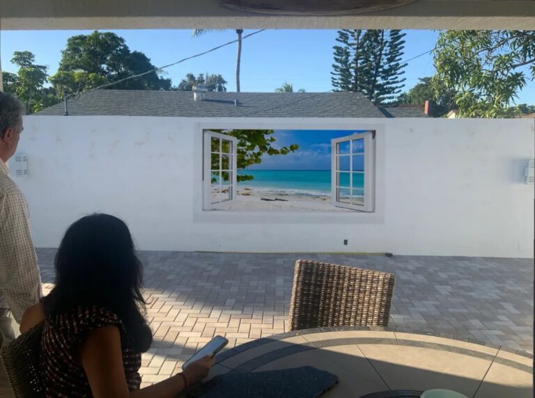 Open windows onto a beach, printed on an outdoor patio wall