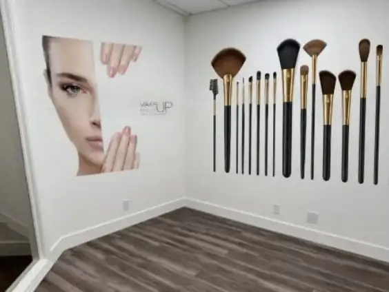 A face and a row of makeup brushes printed on the walls of a makeup studio