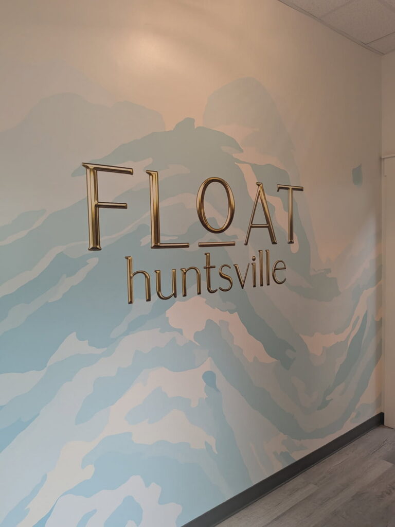Float Huntsville logo and abstract blue mural printed directly on a spa lobby wall by Modrn Ink Wall Printing