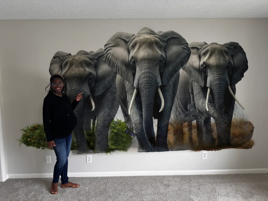Three elephants printed life size on a living room wall, with a woman pointing at the print