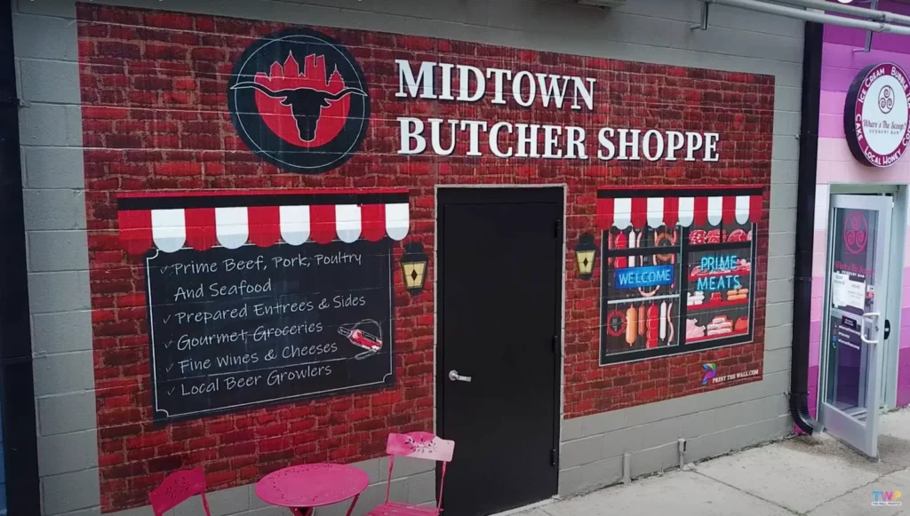 Midtown Butcher Shoppe storefront printed directly onto a brick wall with a striped awning and menu board