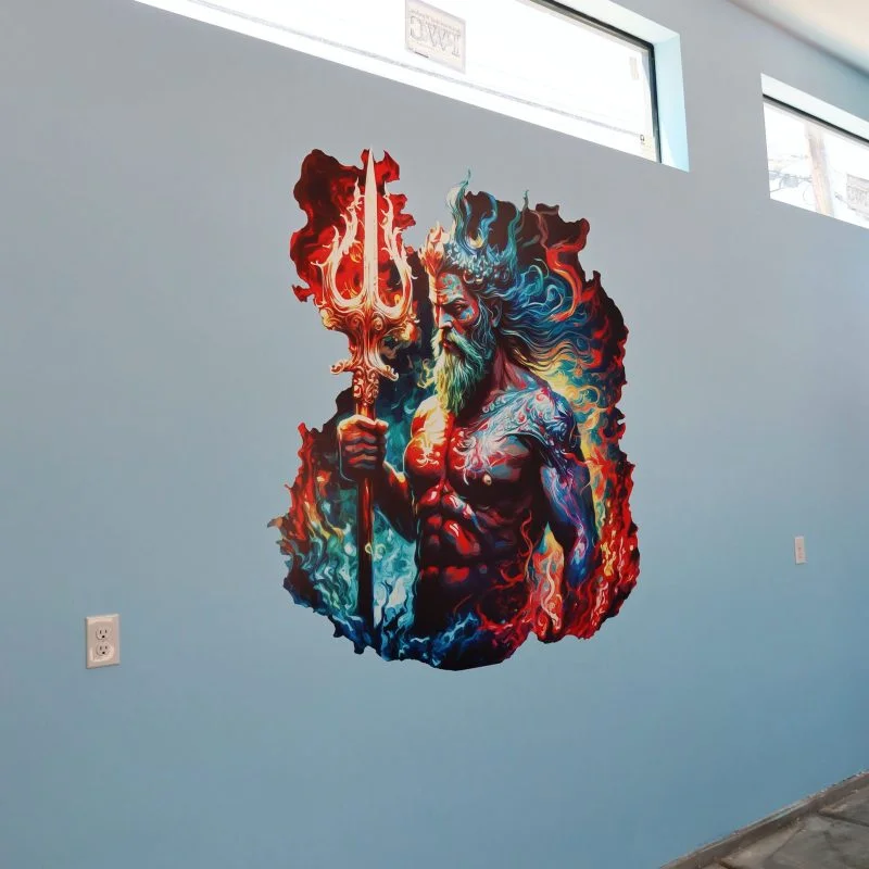 A sea god with a trident printed in fiery color on a pale blue wall