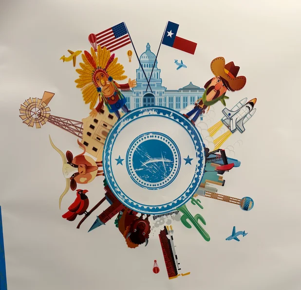 A circle of Texas landmarks and icons printed on a white wall