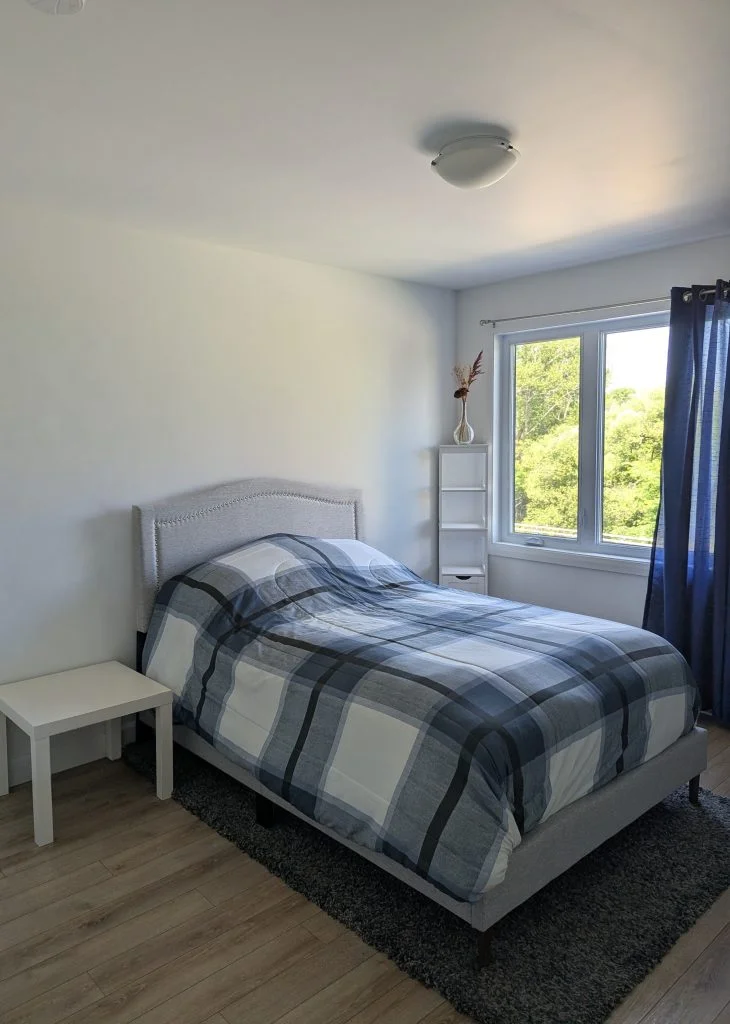 A plain white bedroom wall above a bed, before printing