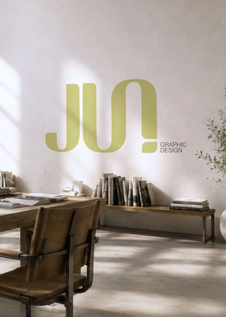 A large gold studio logo printed on a white wall above a desk
