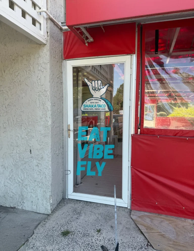 Eat Vibe Fly lettering and a hand graphic printed on a glass shop door