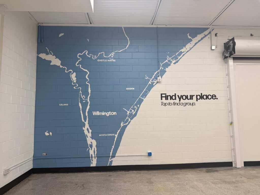 Wilmington area map mural printed on a painted cinder block wall at The Bridge Church with the message Find your place