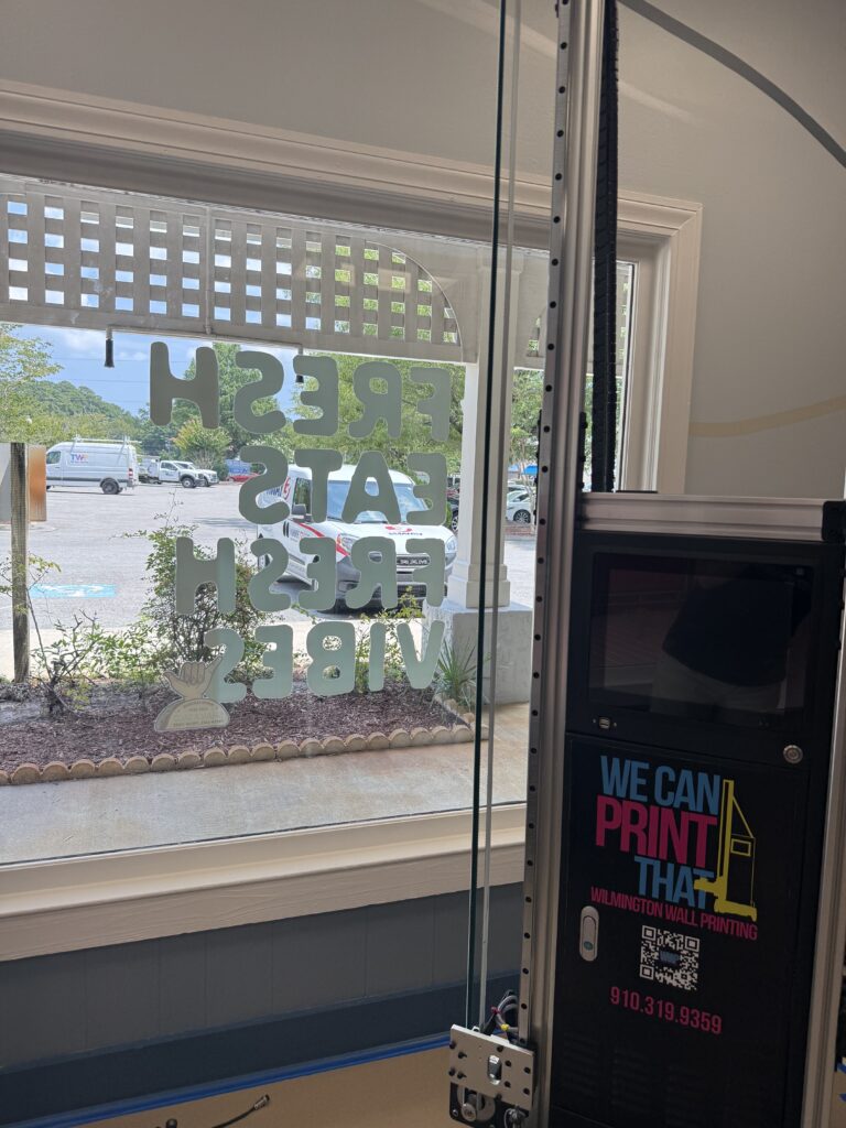 Wilmington Wall Printing machine beside white Fresh Eats Fresh Vibes lettering printed on a restaurant window